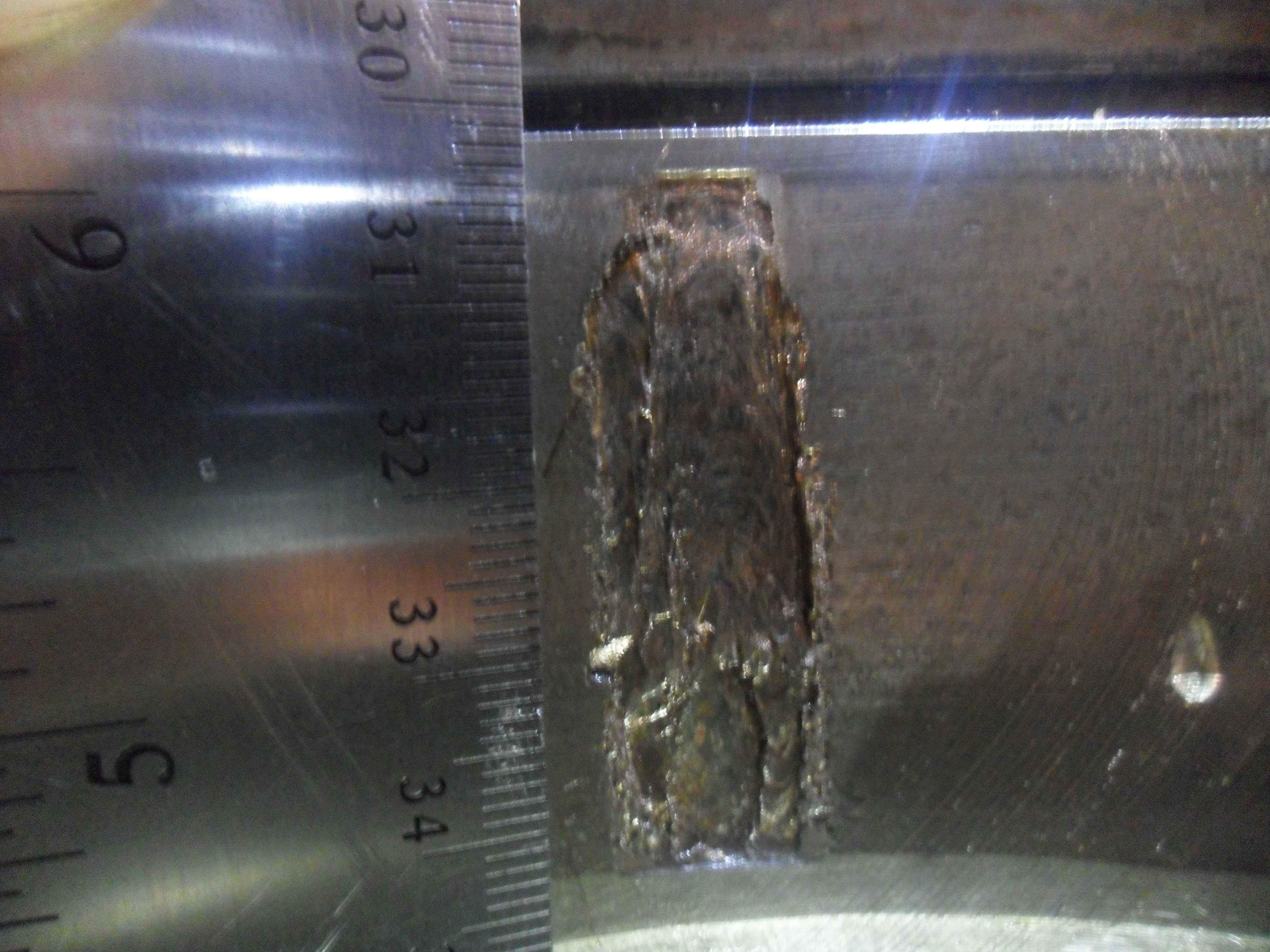 A spall of size 0.521 in² on a cup.